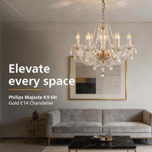 A gold and crystal chandelier hangs in a styled living room above a gray sofa, with large text on the left reading 'Elevate every space' and product text 'Philips Majeste K9 6H Gold E14 Chandelier'.